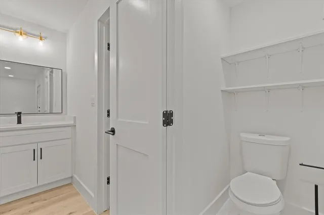 a bathroom with a toilet a sink a vanity and mirror