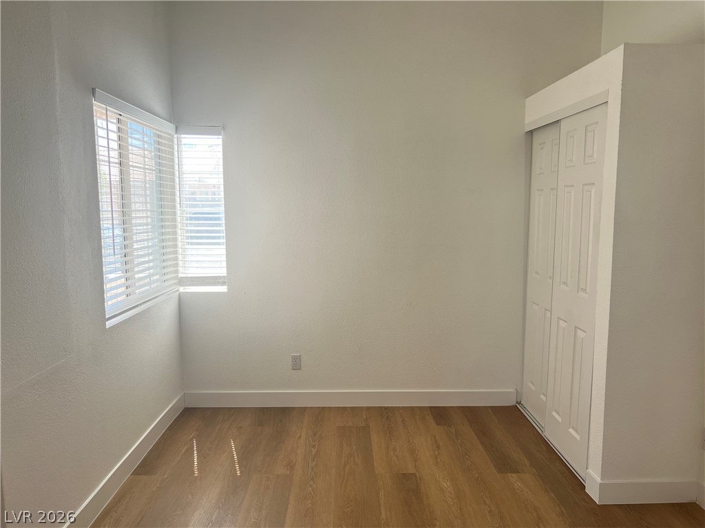 1309 Goldenglow Road Las Vegas, NV 89108 - Photo 8 of 11 Hardwood-style flooring and corner windows enhance this well-lit, adaptable room.
