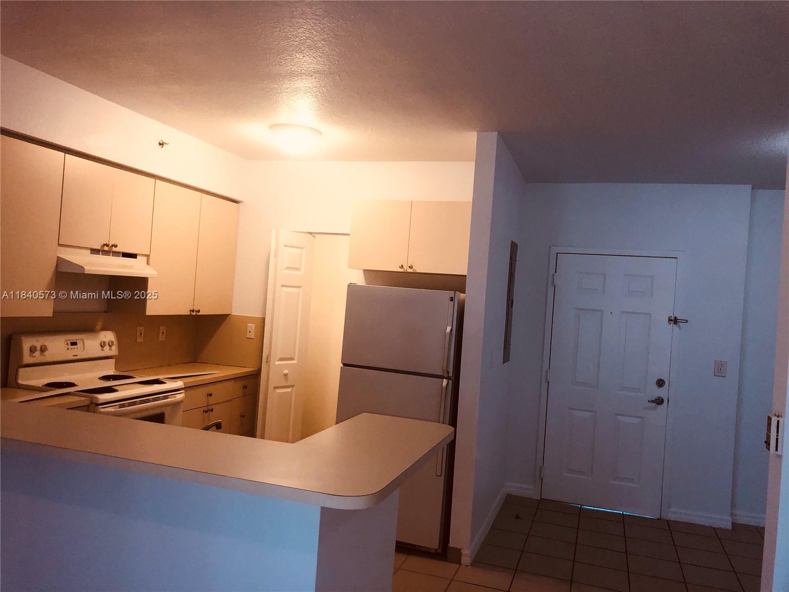 11060 Southwest 196th Street, Unit 601 Cutler Bay, FL 33157 - Photo 6 of 9 a kitchen with stainless steel appliances a refrigerator and a stove top oven
