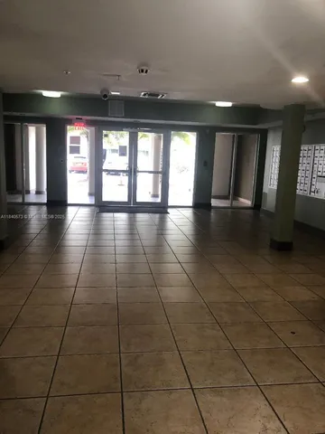 a view of an empty room with window and chandelier fan
