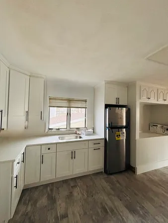 a kitchen with a sink a refrigerator and cabinets