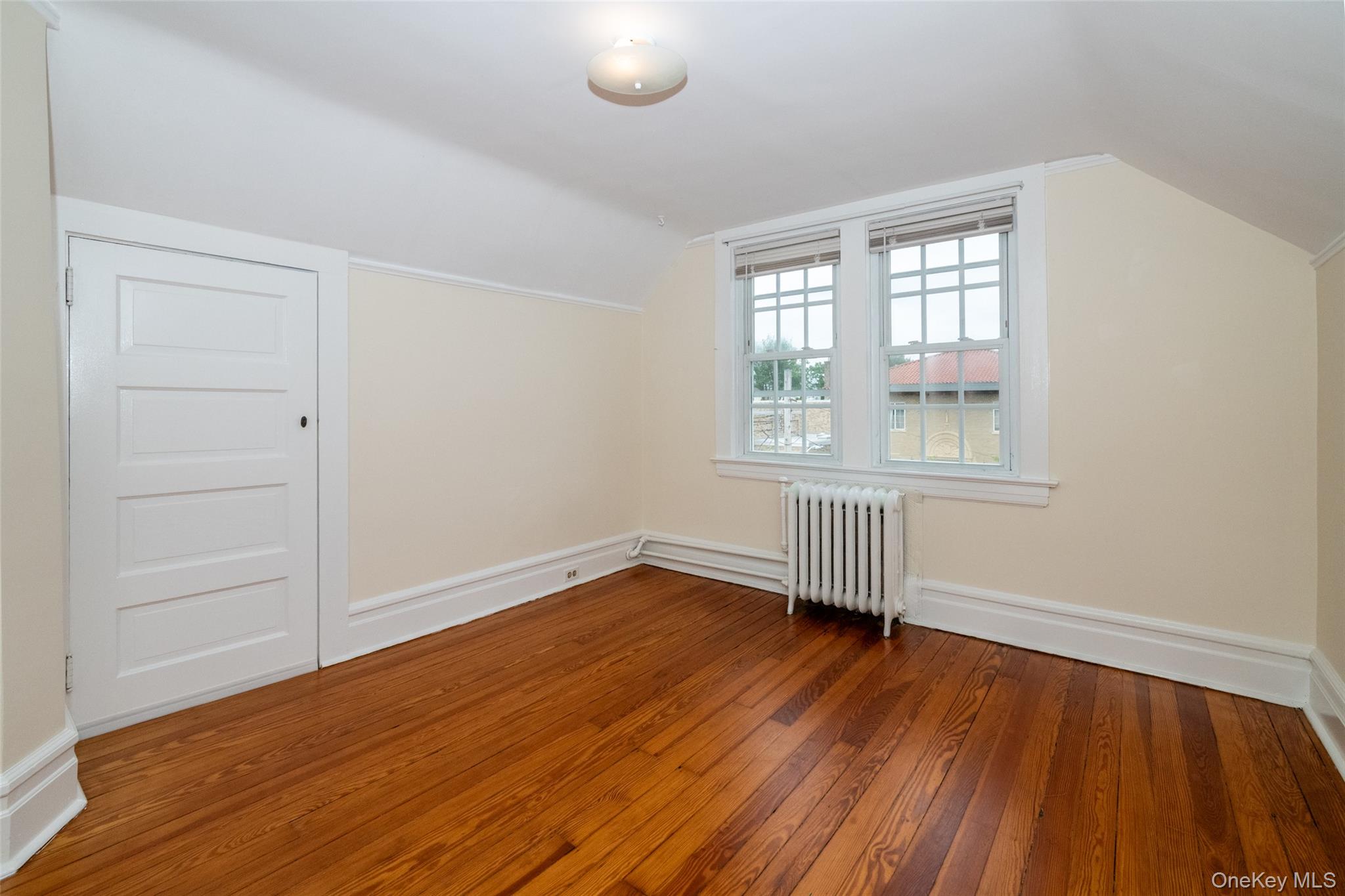 82 Clove Road New Rochelle, NY 10801 - Photo 25 of 39 an empty room with wooden floor and windows