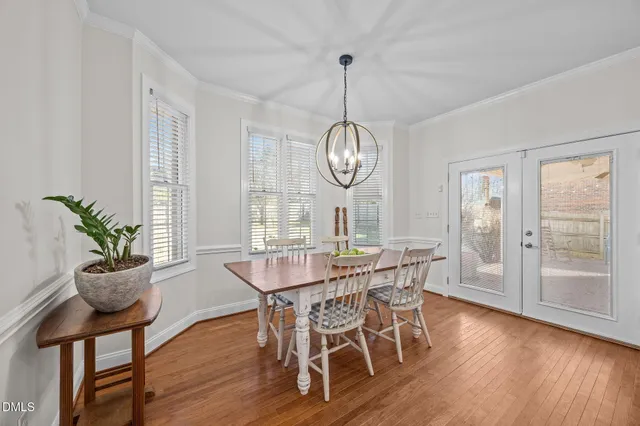 a living room with stainless steel appliances furniture a dining table and chairs