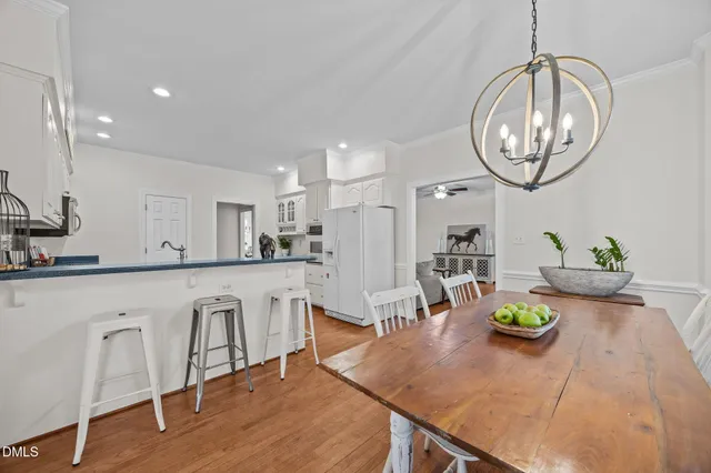 a kitchen with stainless steel appliances a sink a stove a refrigerator cabinets and wooden floor