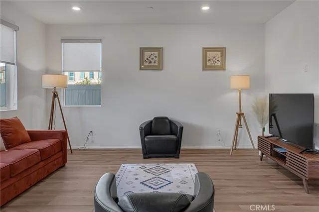 a kitchen with stainless steel appliances granite countertop a dining table chairs refrigerator and cabinets