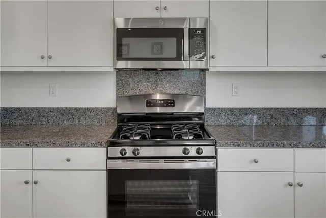a kitchen with granite countertop a table chairs sink and wooden floor