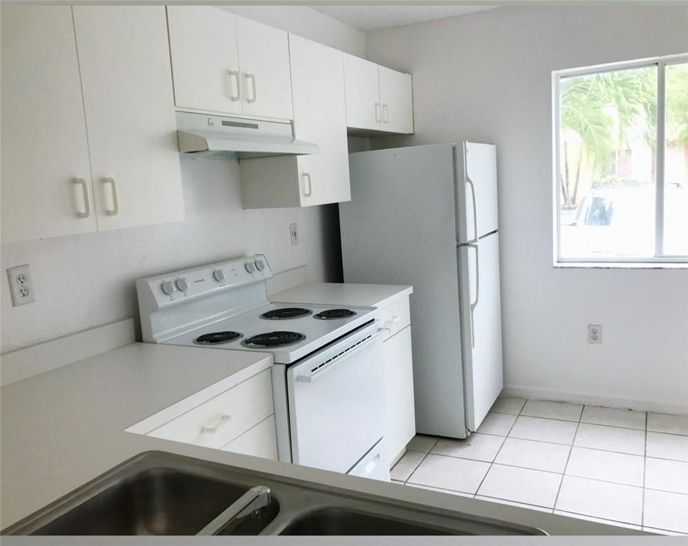 14085 Southwest 179th Terrace Miami, FL 33177 - Photo 3 of 6 a kitchen with a stove a refrigerator and cabinets