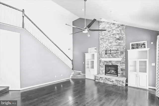 a view of empty room with fireplace and wooden floor