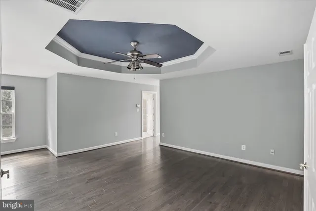 a view of an empty room with wooden floor