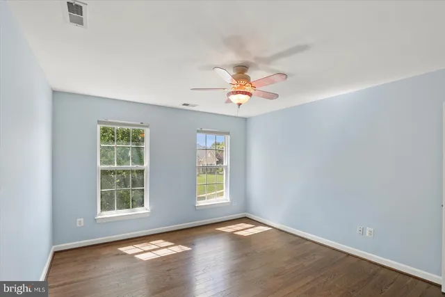 an empty room with wooden floor and window