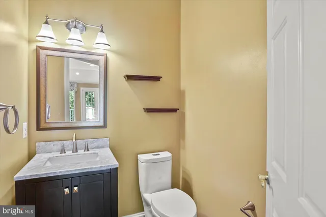 a bathroom with a toilet a sink and mirror