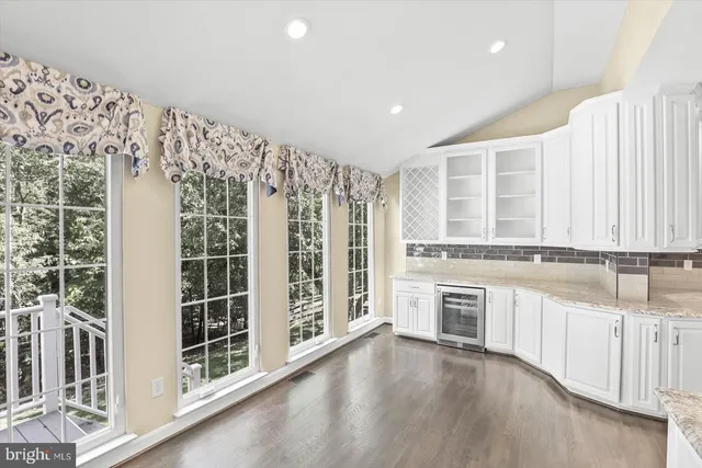wooden floor in an empty room with a kitchen