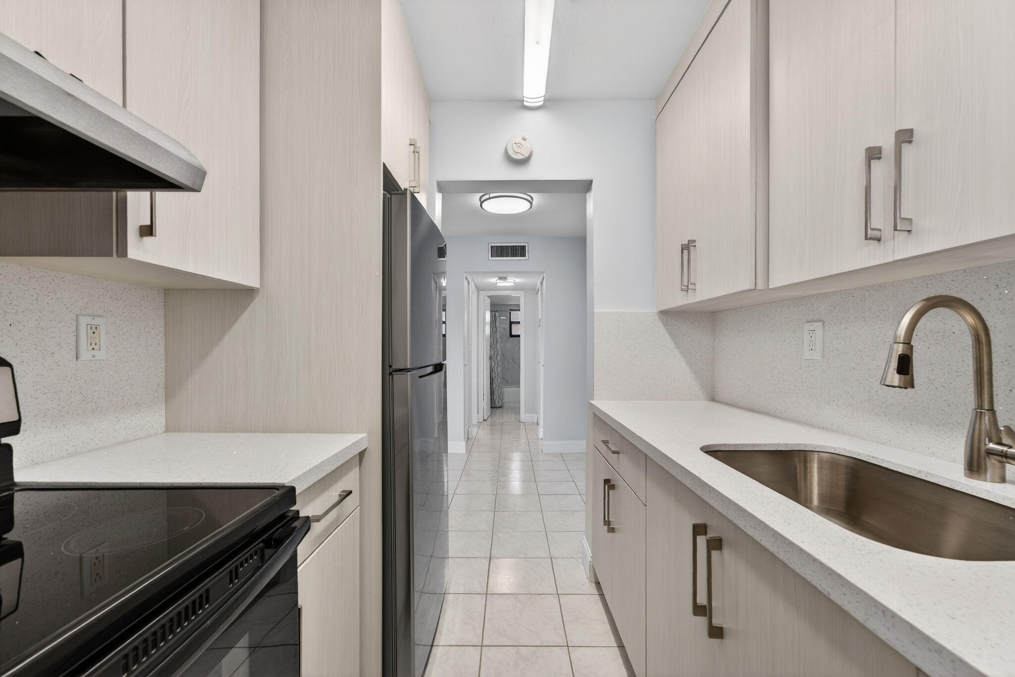 1335 West 68th Street, Unit 208 Hialeah, FL 33014 - Photo 14 of 20 a kitchen with a sink and white cabinets