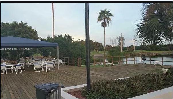 Manors of Inverrary Condominiums Lauderhill, FL 33319 - Photo 15 of 17 a view of a patio with table and chairs potted plants with palm trees