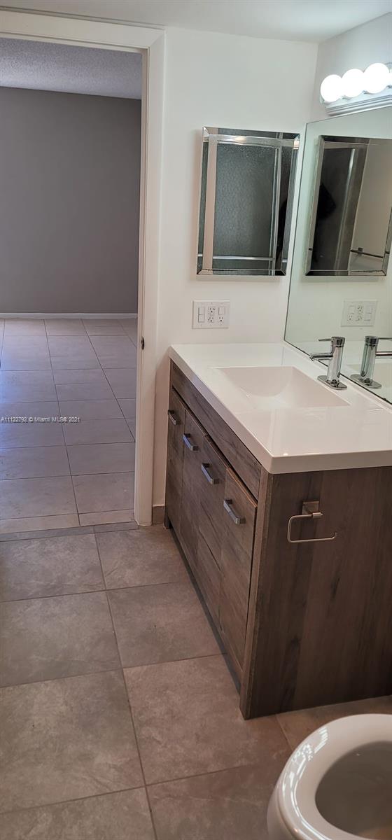Manors of Inverrary Condominiums Lauderhill, FL 33319 - Photo 10 of 17 a bathroom with a sink a toilet a mirror and vanity