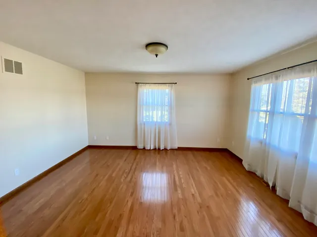 a bedroom with bed and wooden floor