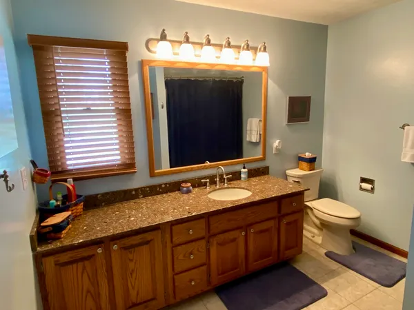 a bathroom with a toilet sink and mirror