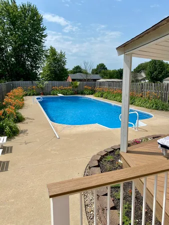a view of a swimming pool with a patio and garden