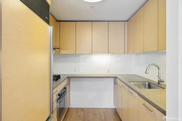 a kitchen with granite countertop a sink a stove and cabinets
