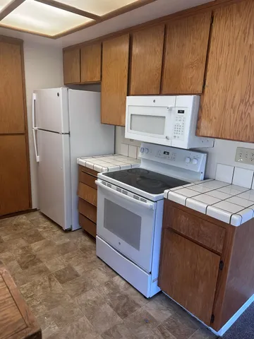 a kitchen with a stove top oven and refrigerator