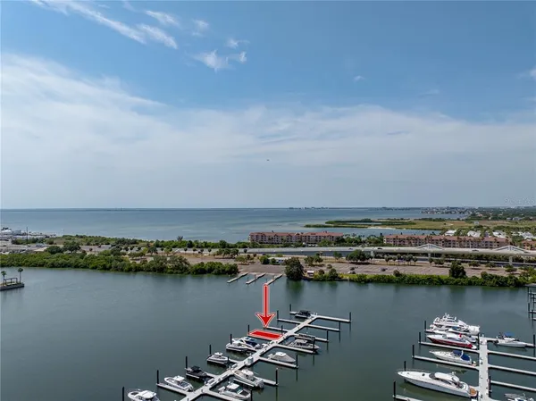 an aerial view of ocean and residential houses with outdoor space