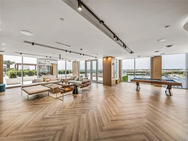 a kitchen with stainless steel appliances granite countertop a stove top oven a sink a dining table and chairs with wooden floor