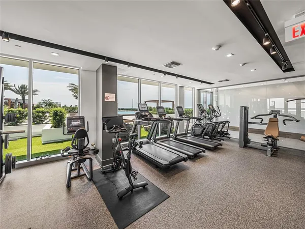 a room with gym equipment and large windows