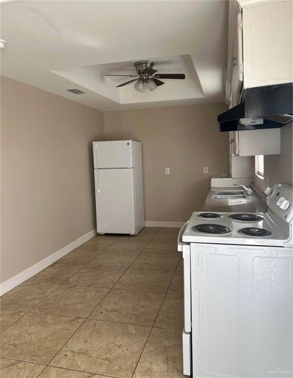 4621 North Jackson Road Edinburg, TX 78541 - Photo 2 of 7 Kitchen space featuring white appliances, a ceiling fan with integrated lighting, and a tray ceiling detail