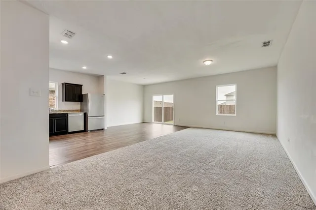 an empty room with windows and fireplace
