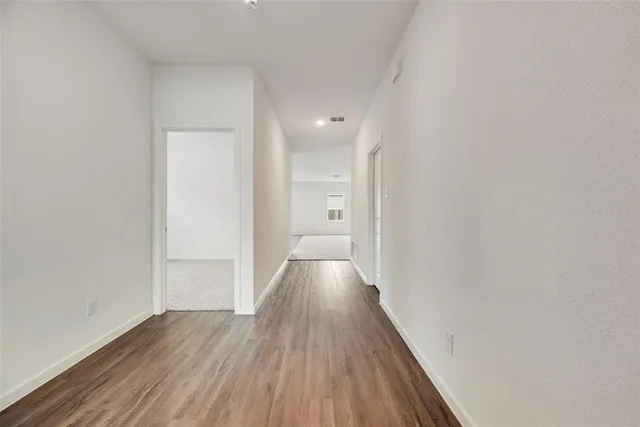 a view of hallway with wooden floor