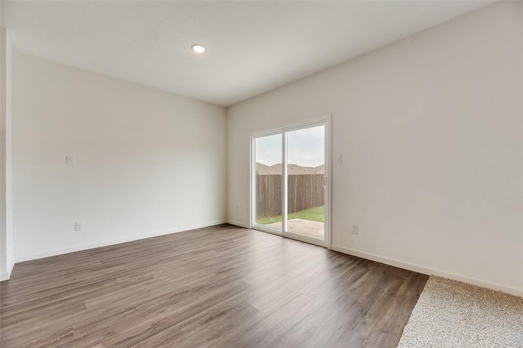 708 Peach Tree Lane Anna, TX 75409 - Photo 19 of 32 an empty room with wooden floor and windows