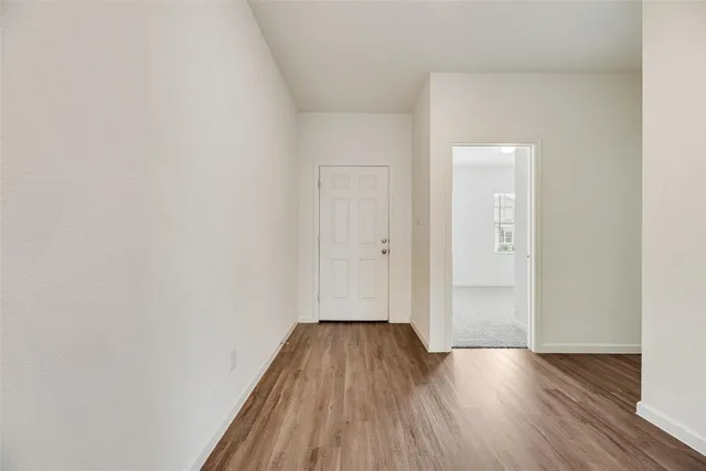 a view of a room with wooden floor and bench