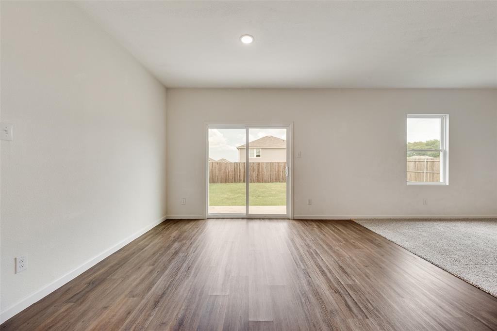 708 Peach Tree Lane Anna, TX 75409 - Photo 4 of 32 a view of an empty room with wooden floor and a window