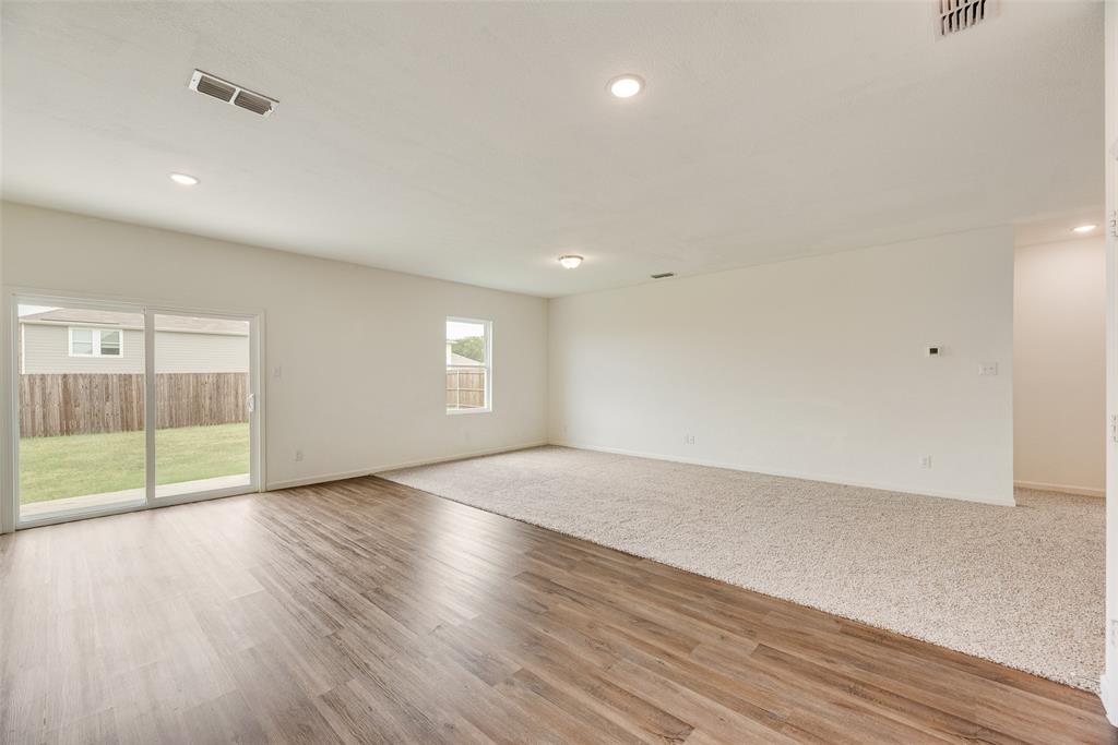 708 Peach Tree Lane Anna, TX 75409 - Photo 5 of 32 an empty room with wooden floor and windows