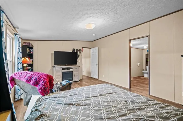 a bedroom with a bed and a flat screen tv