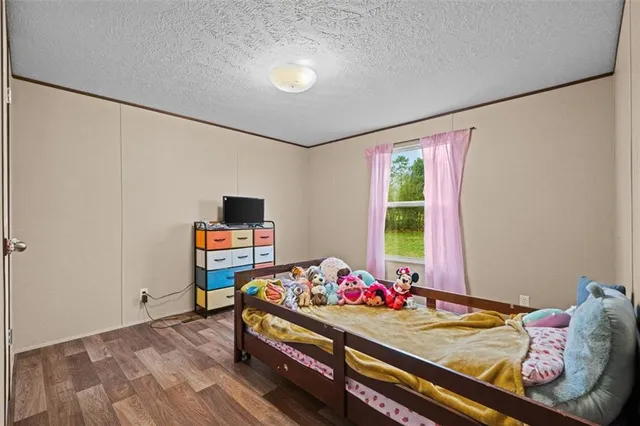 a room with a bed and wooden floor