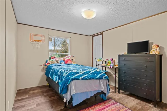 a bedroom with a bed and a dresser next to a window
