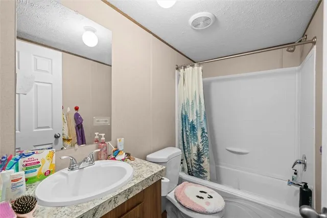 a bedroom with a bed and a flat tv screen on dresser