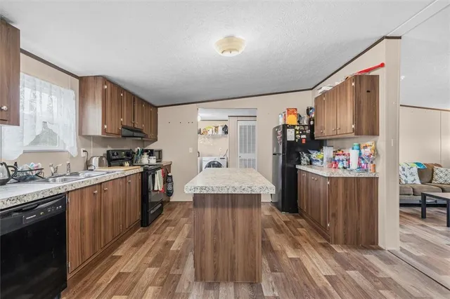 a large kitchen with stainless steel appliances granite countertop a stove and a refrigerator