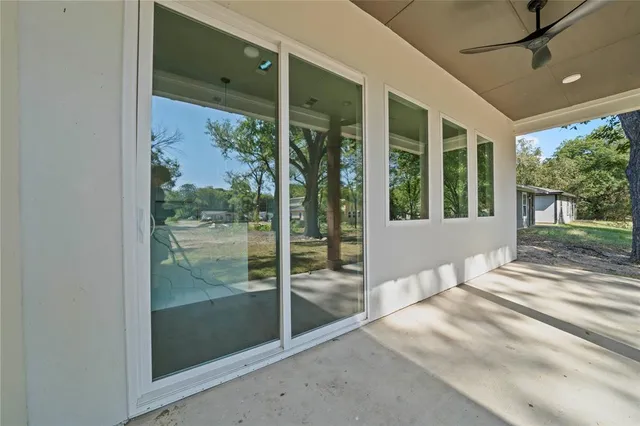 a view of a balcony with a large window and wooden floor