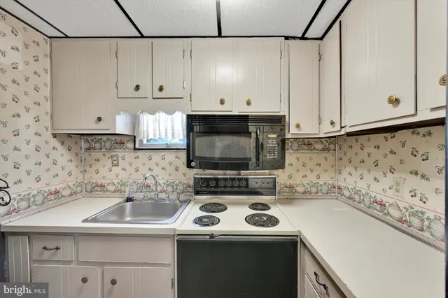 a view of an empty room with a kitchen