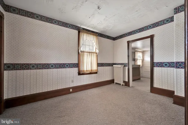 a view of a hallway with furniture and a window