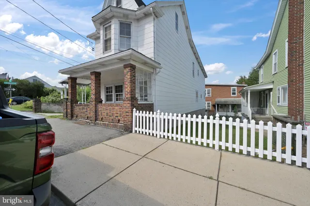 a view of a house with a small yard and wooden fence