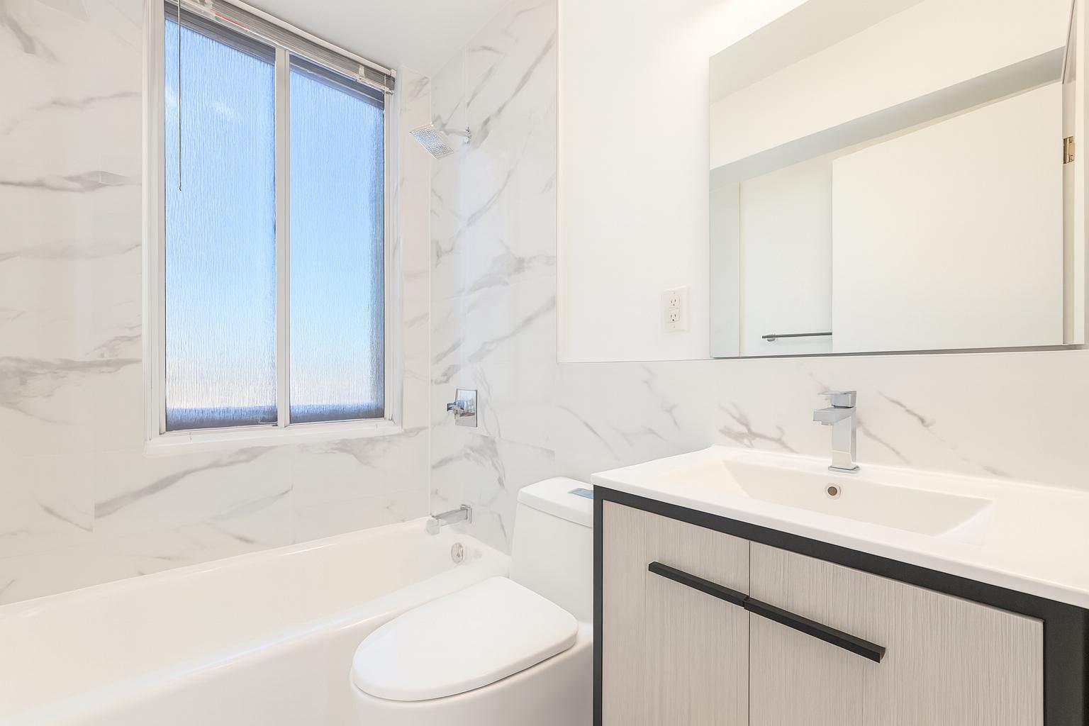 1735 York Avenue, Unit 12H Manhattan, NY 10128 - Photo 8 of 23 a bathroom with a sink a toilet and bathtub