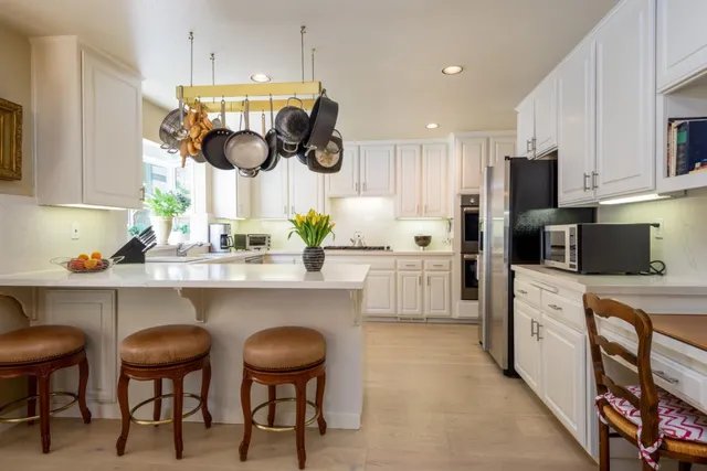 a kitchen with stainless steel appliances a stove a sink and a window