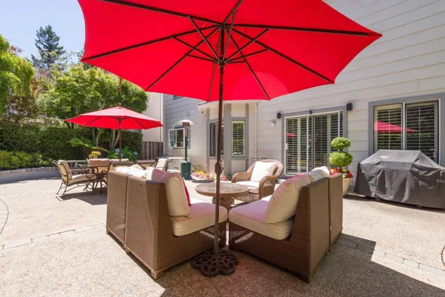 a patio with a table and chairs under an umbrella