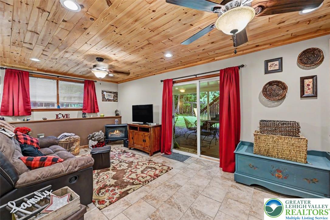 386 Upper Rdg Drive Effort, PA 18330 - Photo 32 of 56 A relaxed living space with a warm wood-paneled ceiling opens directly to an outdoor area, ideal for seamless indoor-outdoor enjoyment.