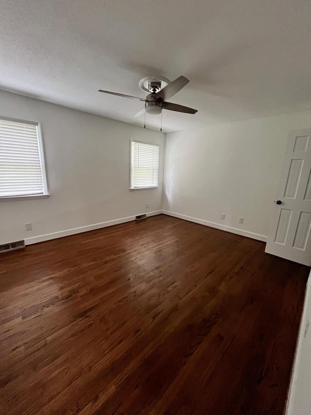3808 Oak Park Road Raleigh, NC 27612 - Photo 19 of 19 an empty room with wooden floor fan and windows