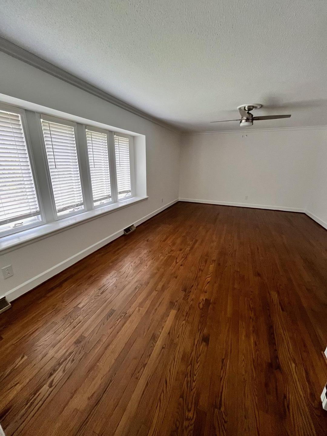 3808 Oak Park Road Raleigh, NC 27612 - Photo 3 of 19 a view of an empty room with a window and wooden floor