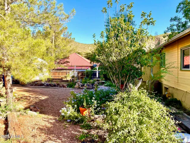 a view of a white house with large windows and a yard
